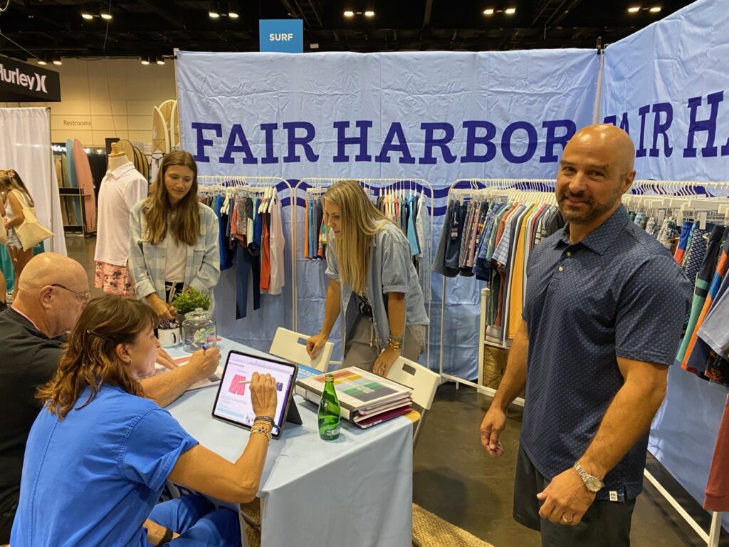 Dale Grimes and Cara Williamson of Tyler's viewing the Fair Harbor line - Fair Harbor VP of Sales Derek Miller on the right